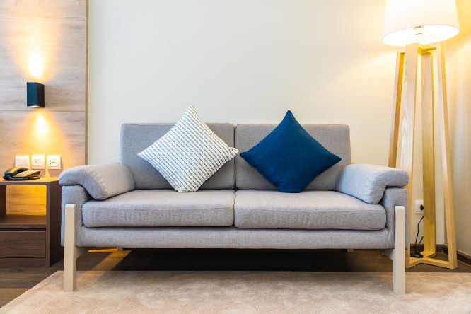 Modern L-shaped sectional sofa in a cozy living room with throw pillows and a rug