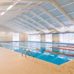 Colorful indoor recreation swimming pool at Midco Aquatic Center with family-friendly features